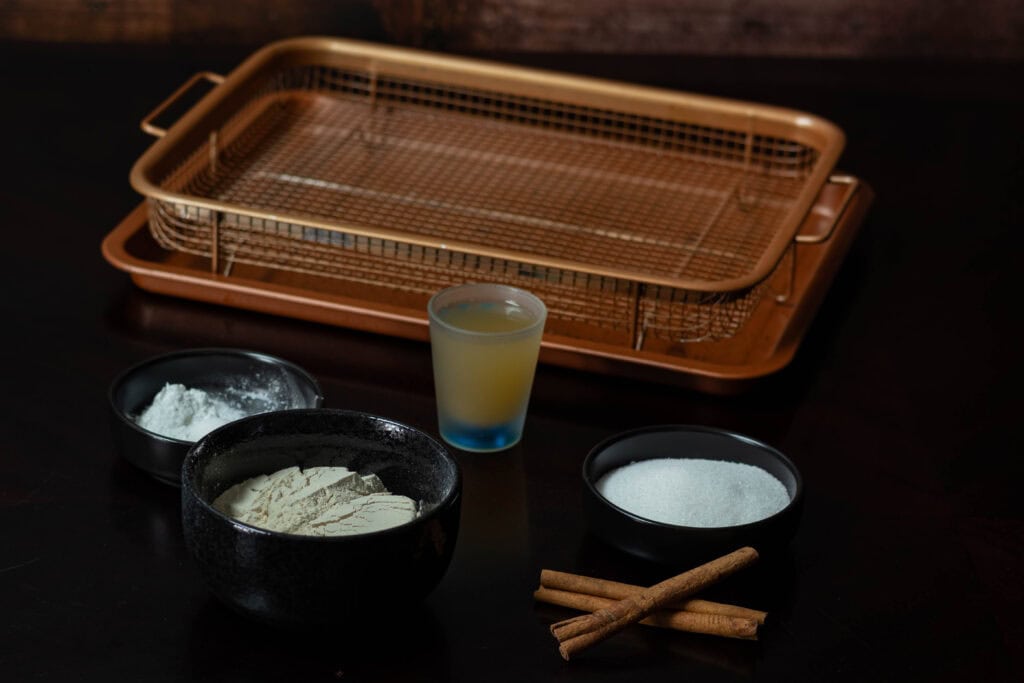 Ingredients for High Protein Cinnamon Sugar Donut Holes - vital wheat gluten, baking soda, salt, sugar, cinnamon, apple cider vinegar and a copper crisping tray.