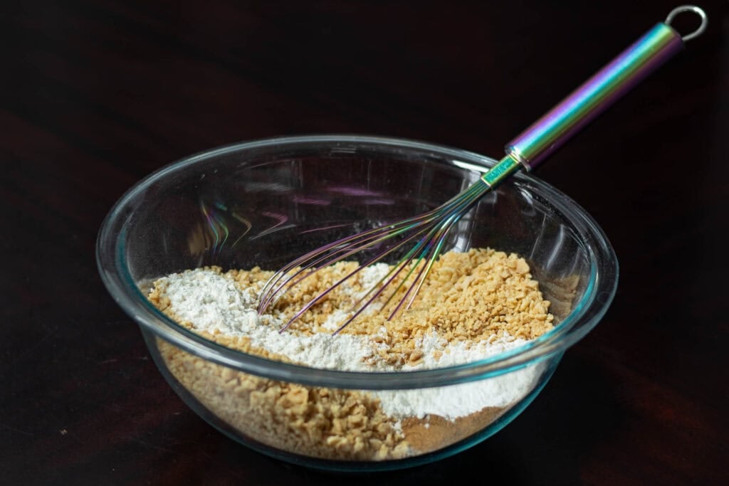 The dry ingredients for the muffins in a large glass bowl with a whisk.