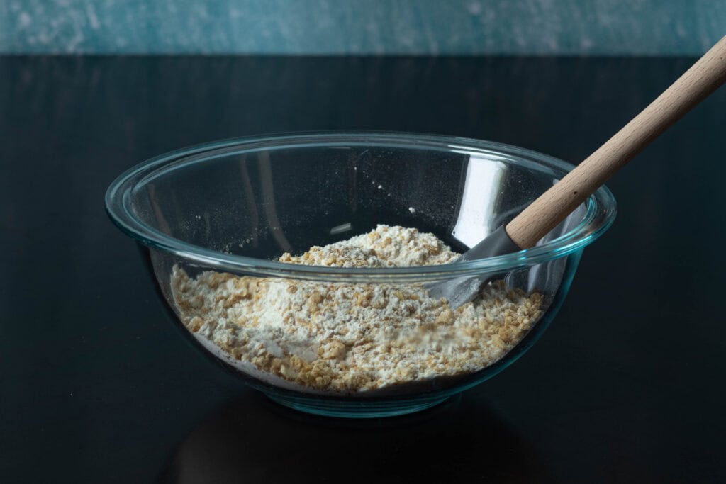 Dry ingredients for the banana nut muffins mixed in a medium sized glass bowl.