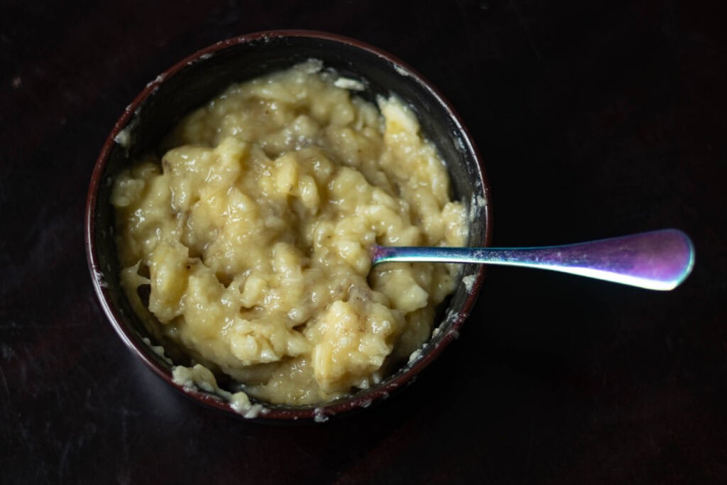 Medium black bowl with mashed bananas.