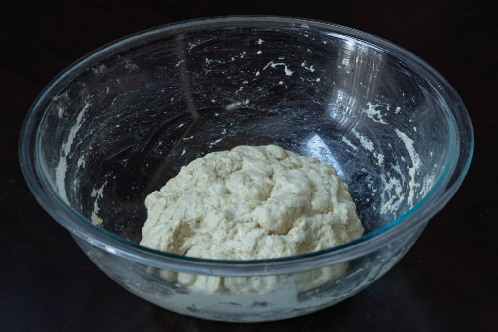 Bread dough in a ball in large glass bowl.