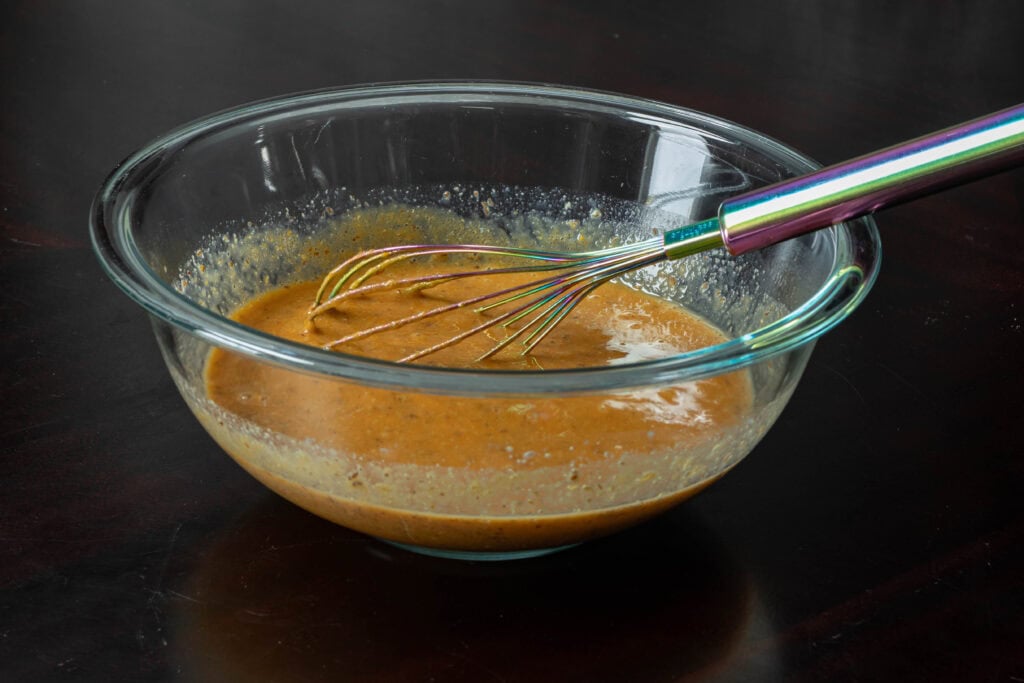 Large glass bowl of mixed wet ingredients.
