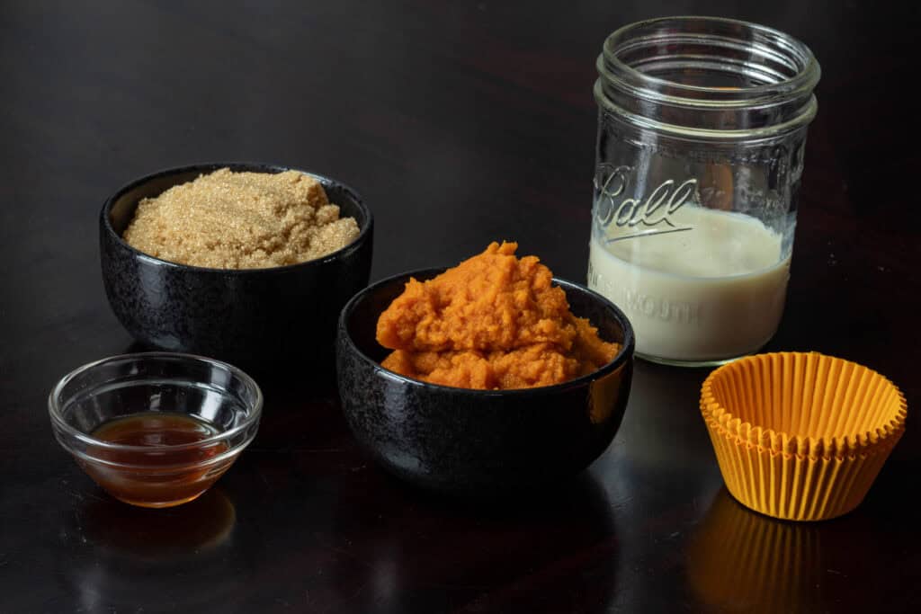 Wet ingredients for Pumpkin Craisin Muffins - vanilla extract, pumpkin puree, brown sugar, and soy milk.