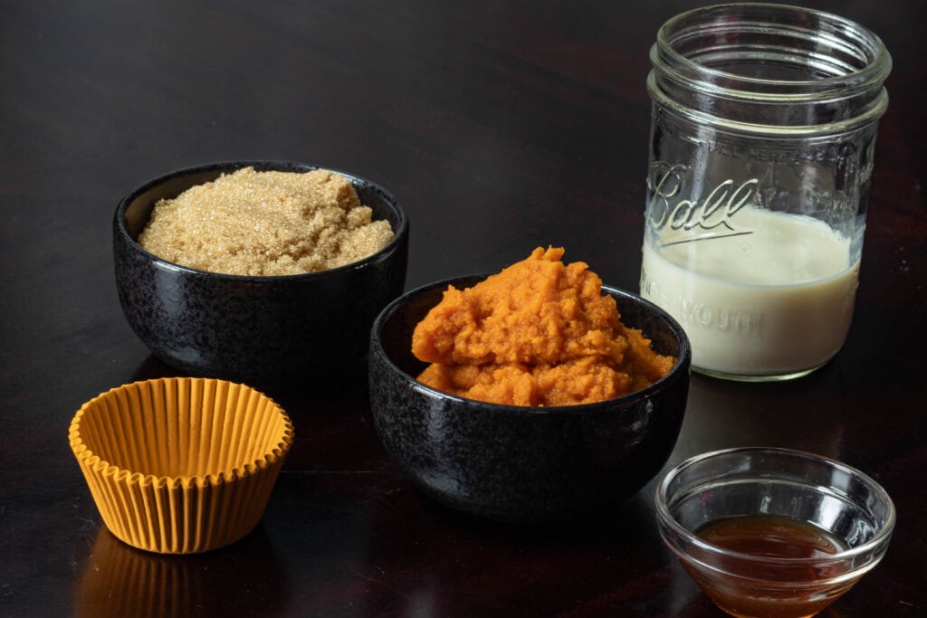 Wet ingredients for muffins - brown sugar, pumpkin puree, vanilla extract and soy milk.