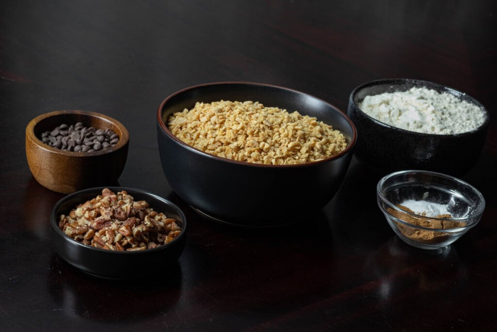 Dry ingredients for muffins - pecans, chocolate chips, TVP, spices, and flour.