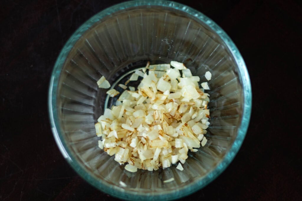 Small glass bowl of sauteed onion and garlic.