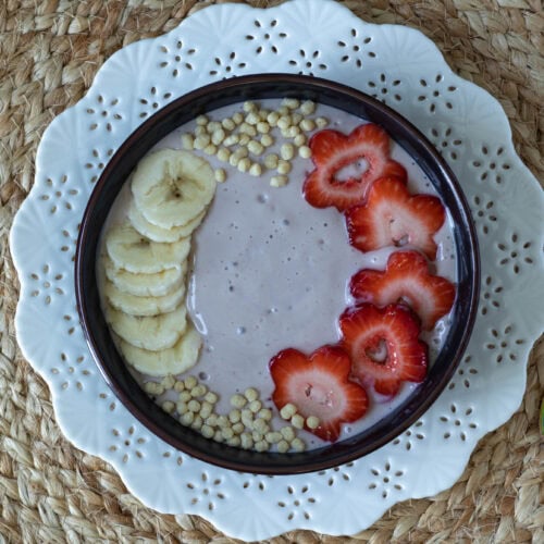 Strawberry and Banana Smoothie Bowl decorated with bananas, strawberries and edamame puffs.