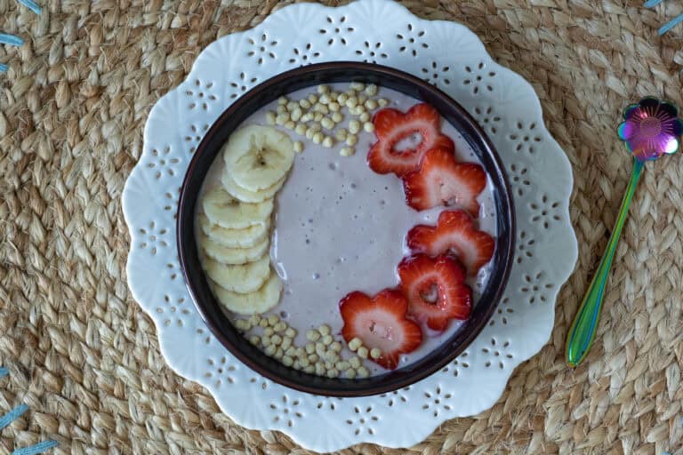 Strawberry and Banana Smoothie Bowl decorated with bananas, strawberries and edamame puffs.