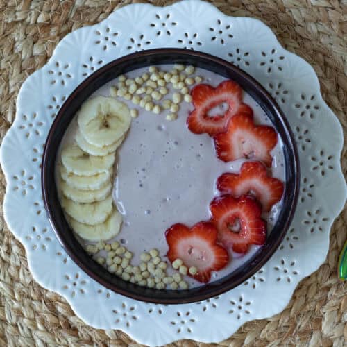 Strawberry and Banana Smoothie Bowl decorated with bananas, strawberries and edamame puffs.