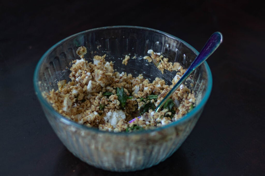 Stuffed portobello mushroom filling in a medium glass bowl.