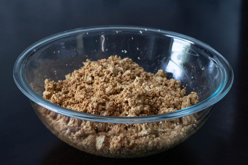 Seasoned and crumbled super firm tofu in a large glass bowl.