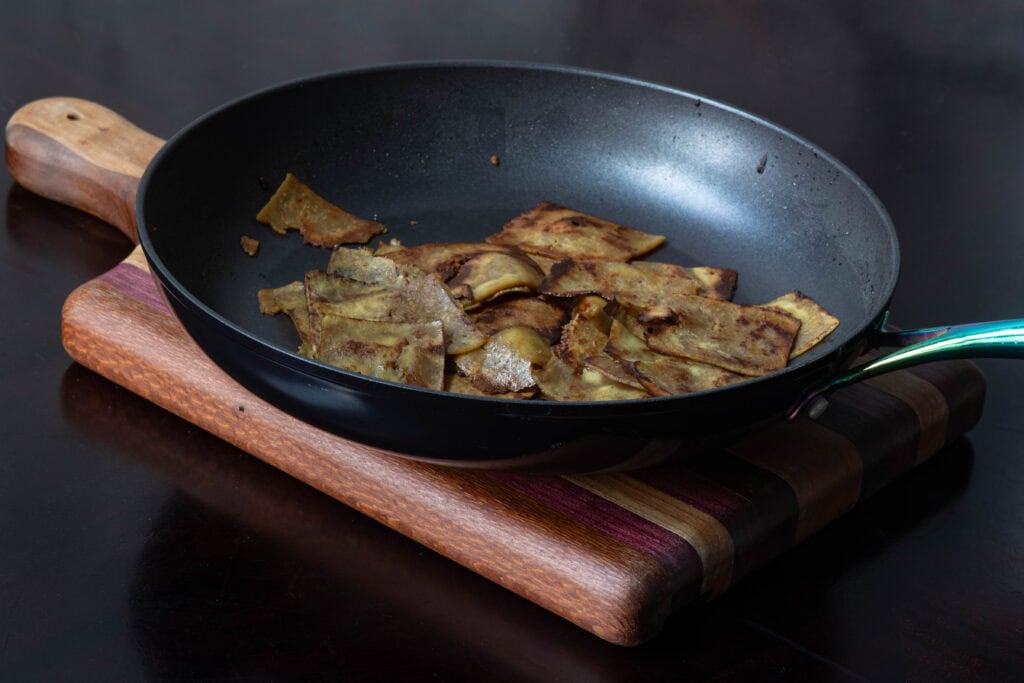 Thinly shaved and marinaded tofu in a sautee pan.