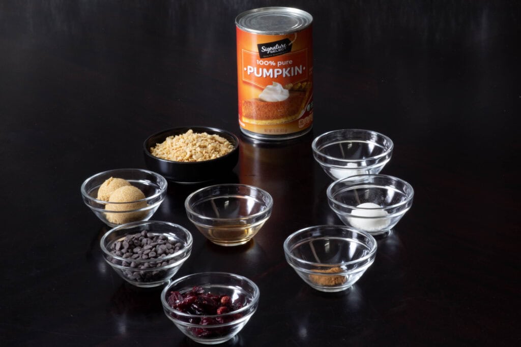 Ingredients for TVP Pumpkin Cookies - pumpkin puree, brown sugar, TVP, mini chocolate chips, craisins, vanilla, spices, flour, salt and baking powder.