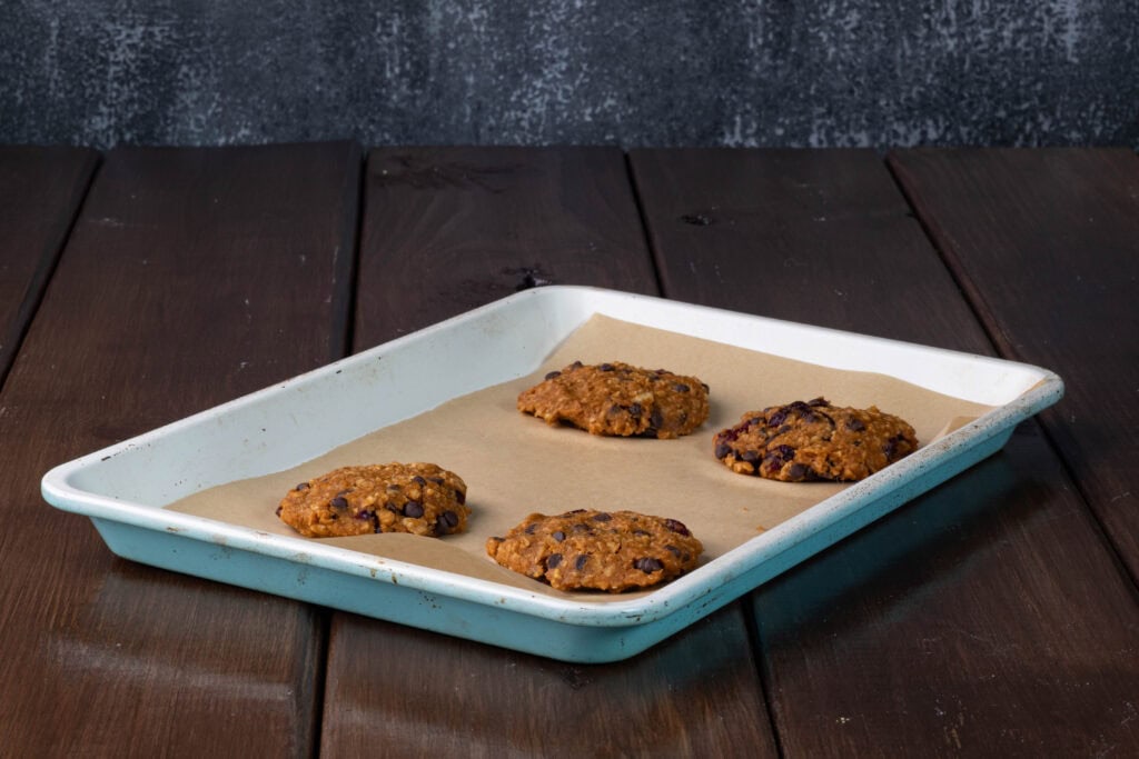 Uncooked pumpkin tvp cookies on a parchment paper-lined baking sheet.