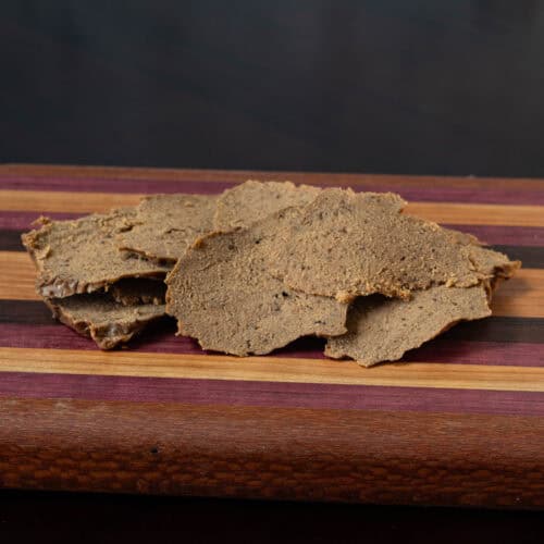 Thinly sliced seitan steak on a wooden cutting board.