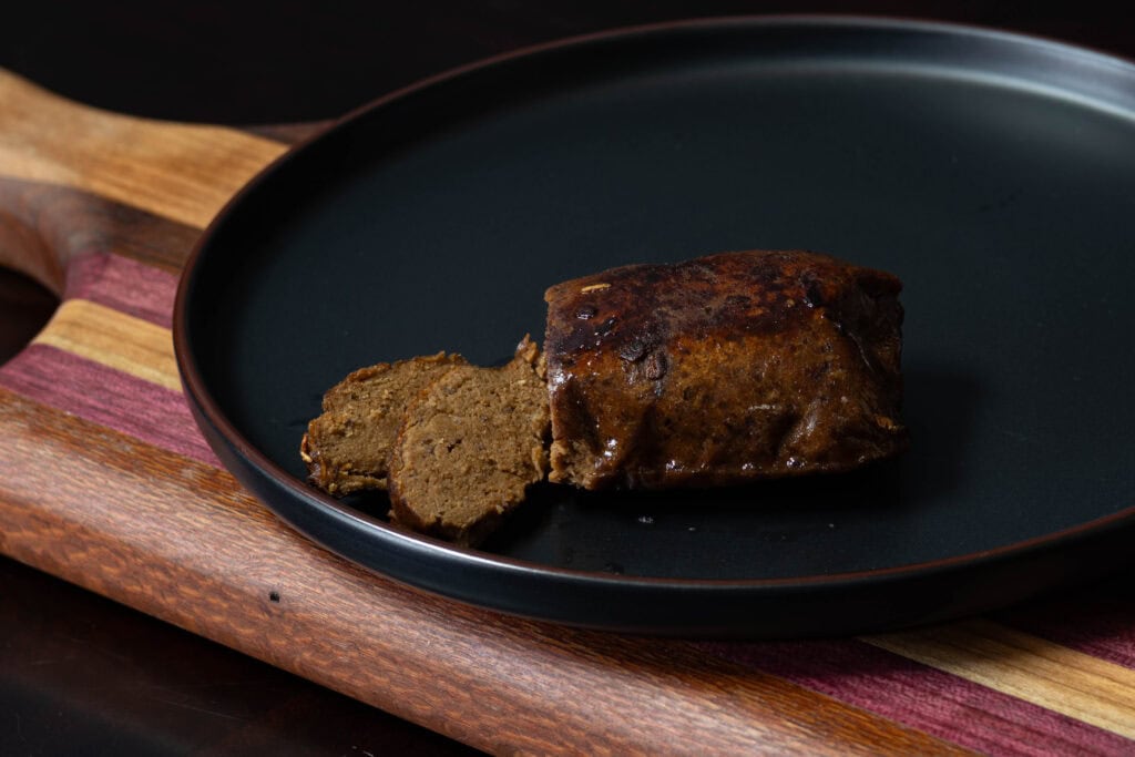 Seitan steak on a wooden cutting board.