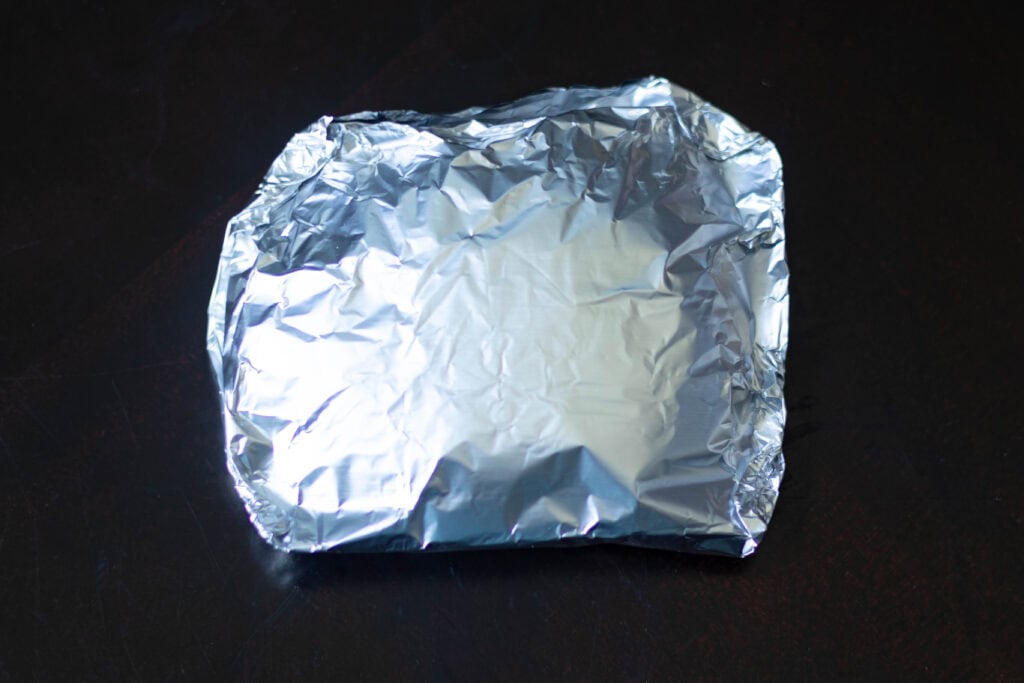 Seitan steak tightly wrapped in foil.
