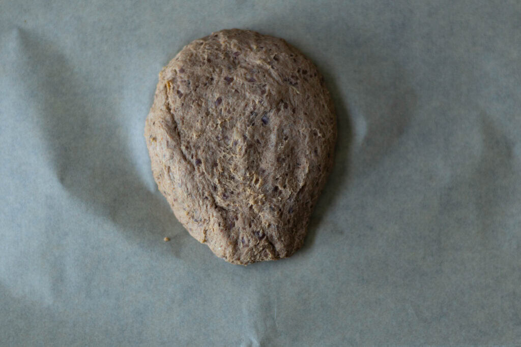 Uncooked seitan steak sitting on parchment paper.