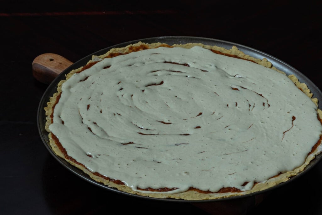 Uncooked pizza with liquid mozzarella on top.