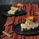 High Protein pumpkin spice "rice" crispy treats on a fall decorated table.