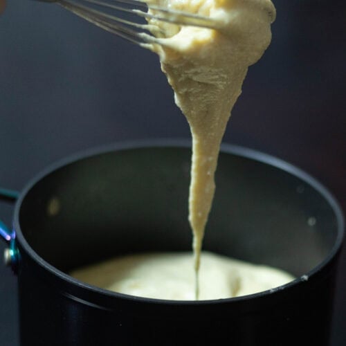 Stretchy soy mozzarella dripping from a whisk.