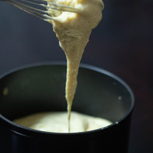 Stretchy soy mozzarella dripping from a whisk.