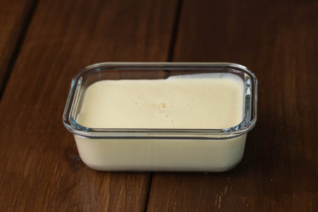 Fresh vegan mozzarella stored in a tupperware container.