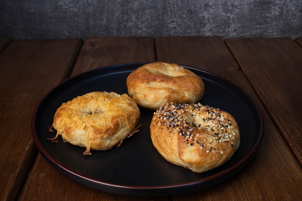 Plate with three high protein bagels - toasted parmesan, everything and plain.