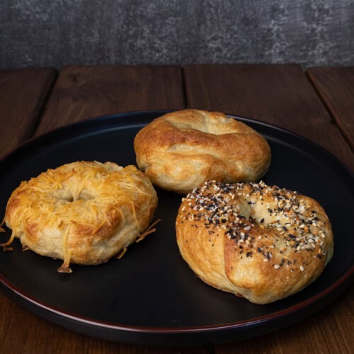 Plate with three high protein bagels - toasted parmesan, everything and plain.