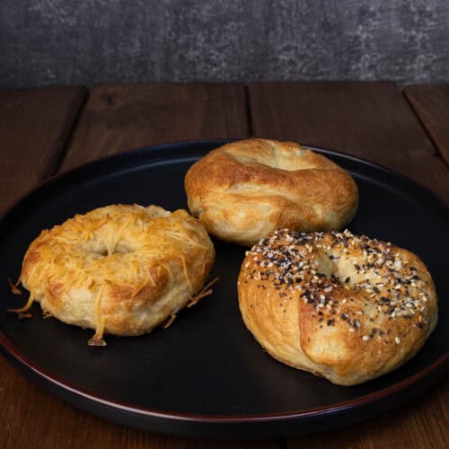 Plate with three high protein bagels - toasted parmesan, everything and plain.