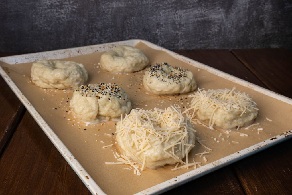 Uncooked bagels with toppings.