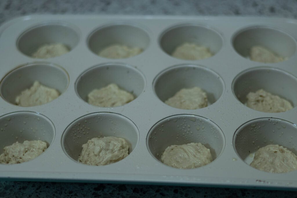 High protein pizza dough divided across muffin tin.