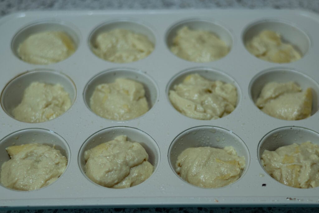 Uncooked pizza bites in a muffin tin.