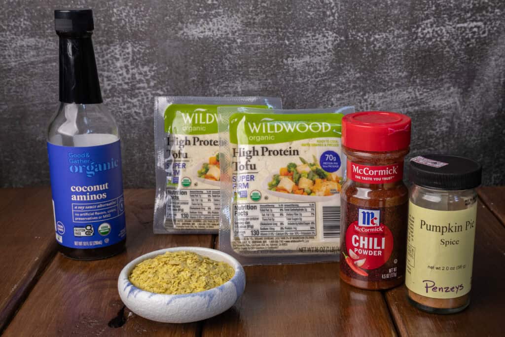 Ingredients for the tofu crumble - coconut aminos, super firm tofu, nutritional yeast, chili powder and pumpkin pie spice.