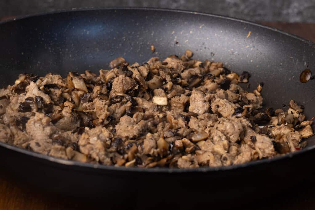 Sauteed mushrooms and sausage chunks.