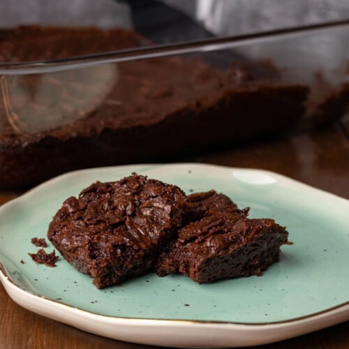Vegan brownies on a pretty blue plate.