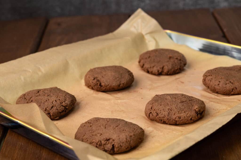Baked cookies on a parchment paper lined baking sheet.