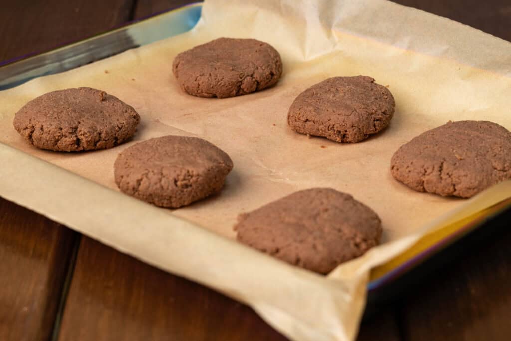 Cookie dough shaped and unbaked on a cookie sheet.
