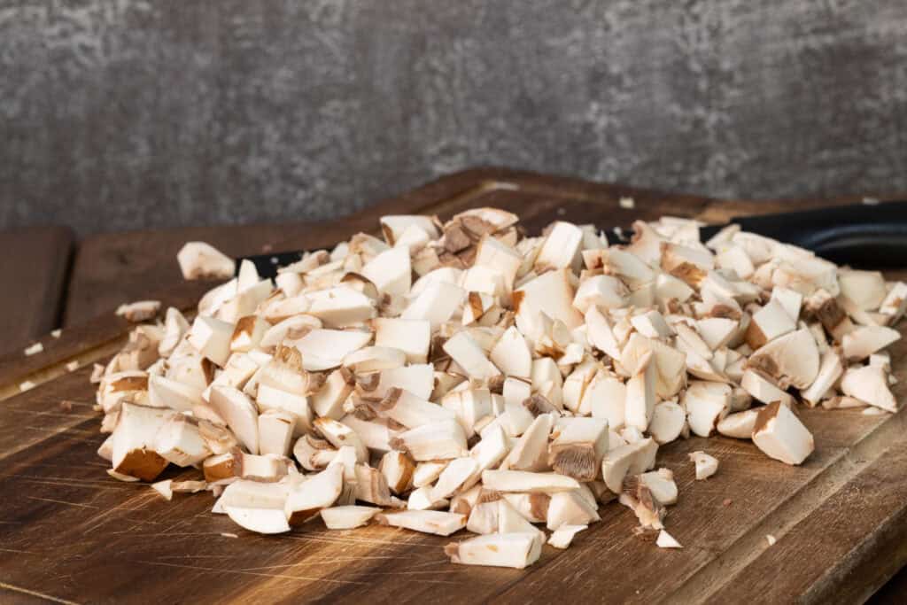 Finely chopped mushrooms on a cutting board.