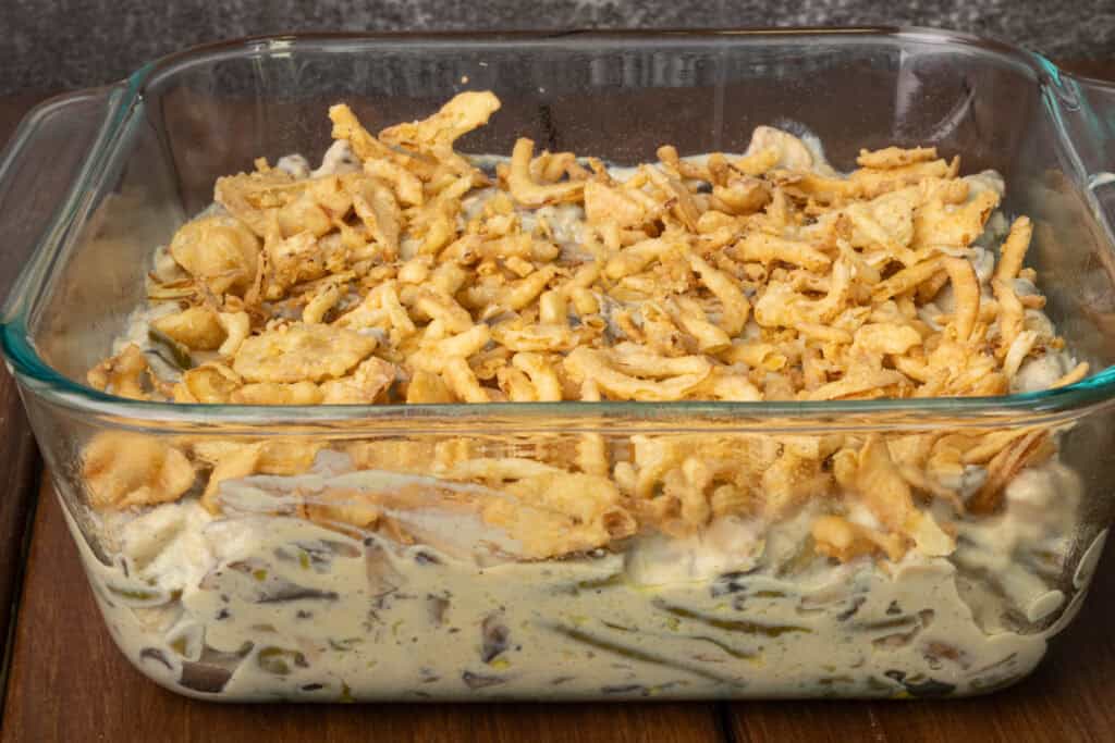 Green bean casserole with onion topping before it goes in the oven.