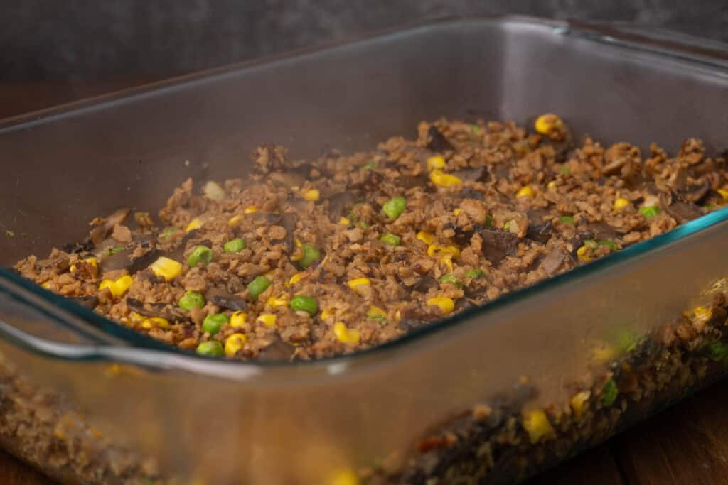 Layer of TVP and veggies in a casserole dish.