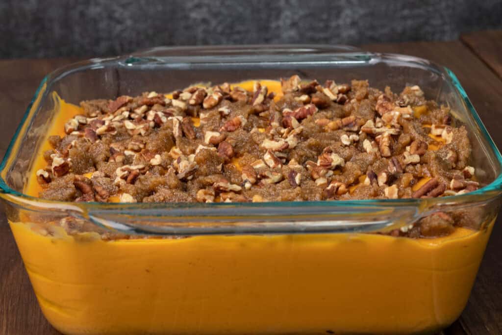 Sweet potato casserole with brown sugar and pecan topping before baking in the oven.