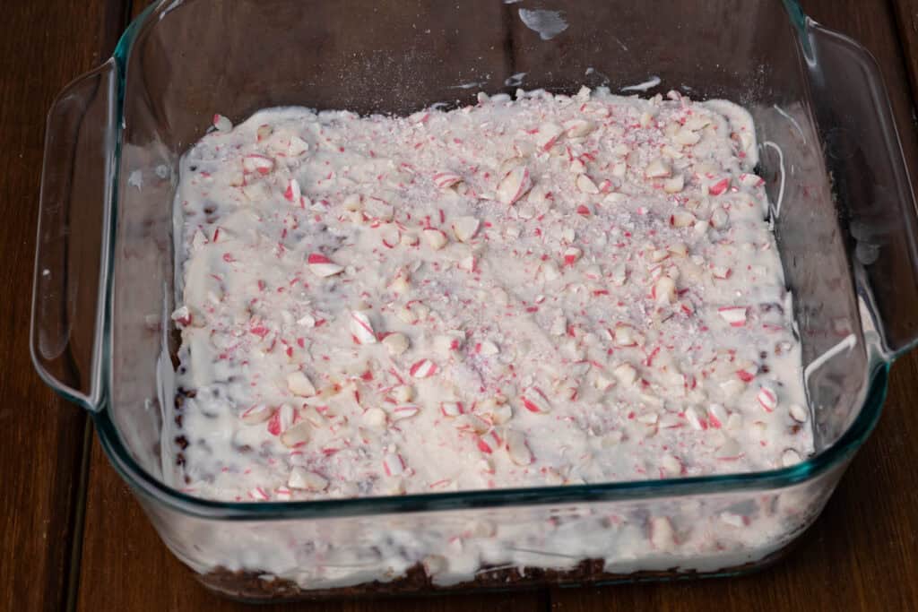 Chocolate rice crispy treats with a white chocolate topping and sprinkling of crushed candy canes.