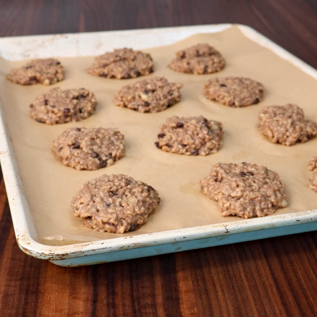 High Protein Banana TVP Cookie dough on a parchment paper-lined baking sheet.