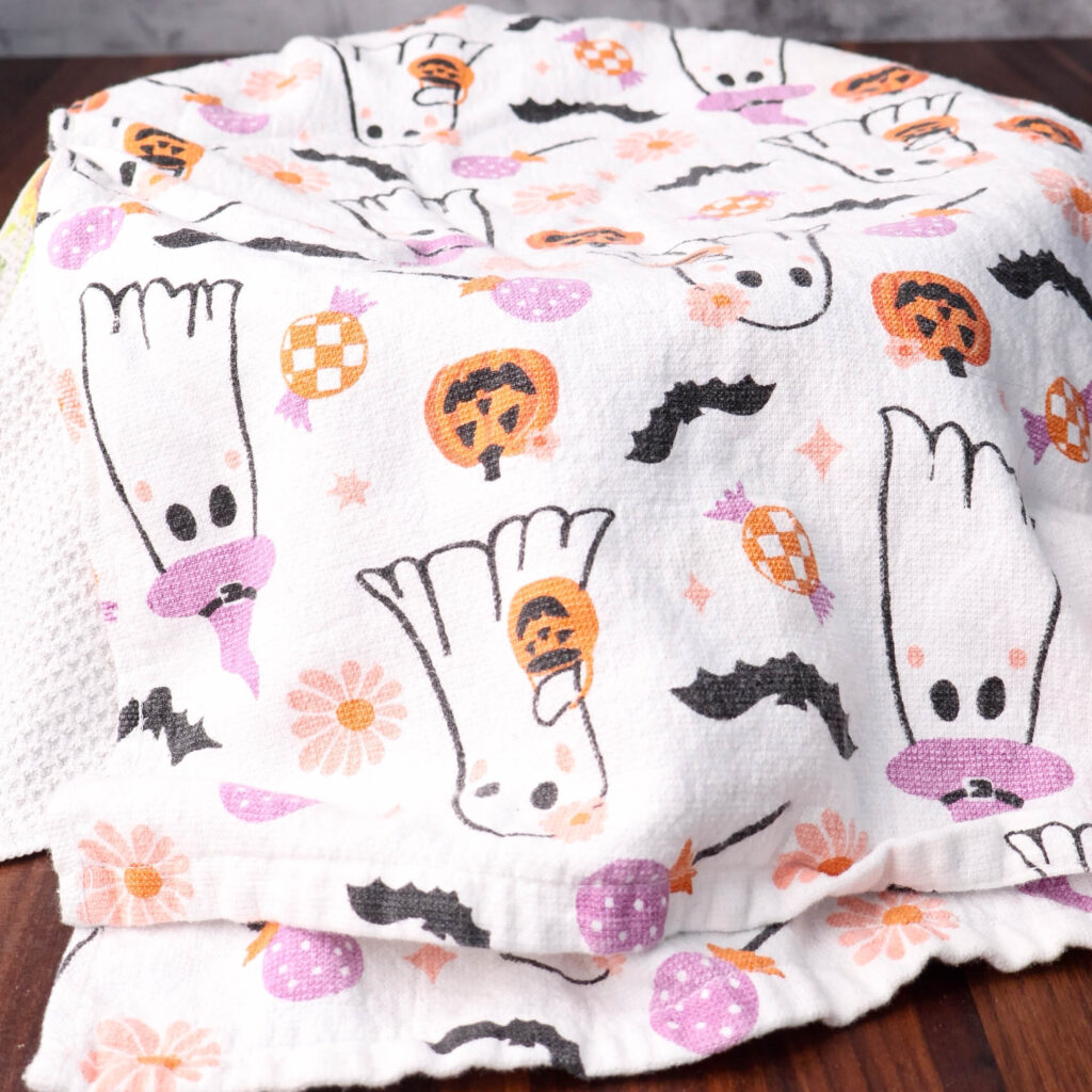 Cinnamon roll dough covered with a kitchen towel.