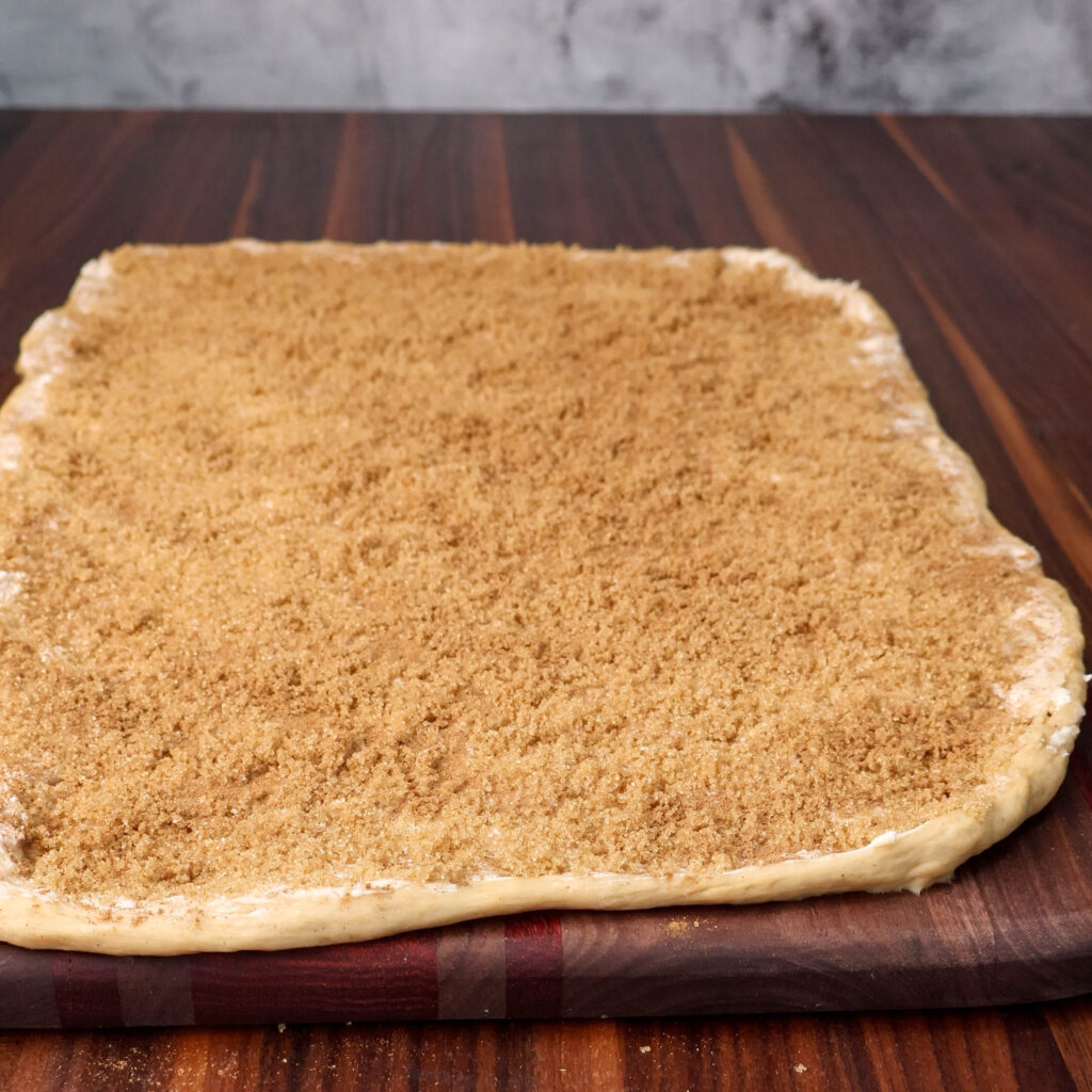 Cinnamon roll dough rolled out with butter, brown sugar and cinnamon.